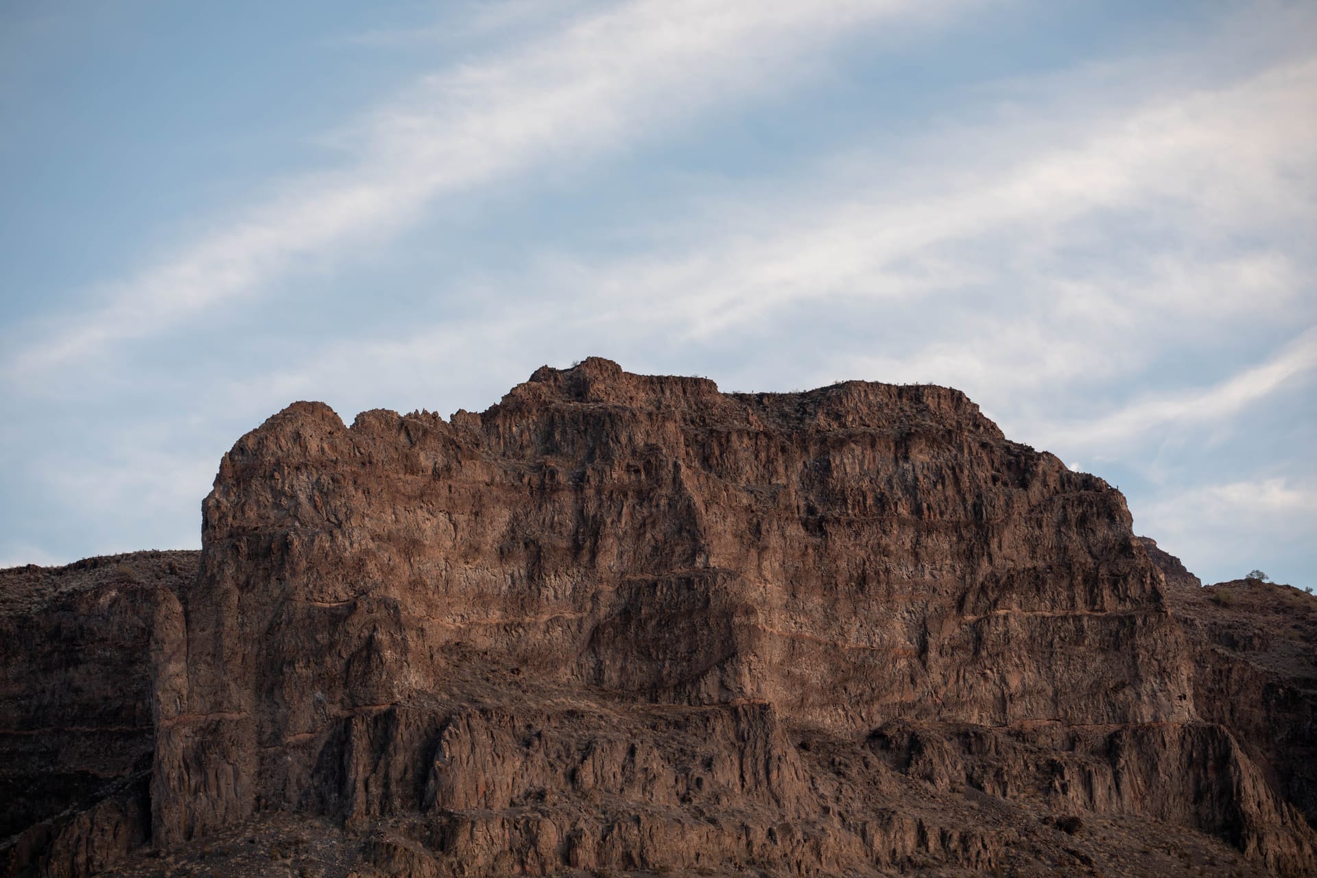 Majestic rocky mesa under blue sky in Parker, AZ, capturing nature's raw beauty