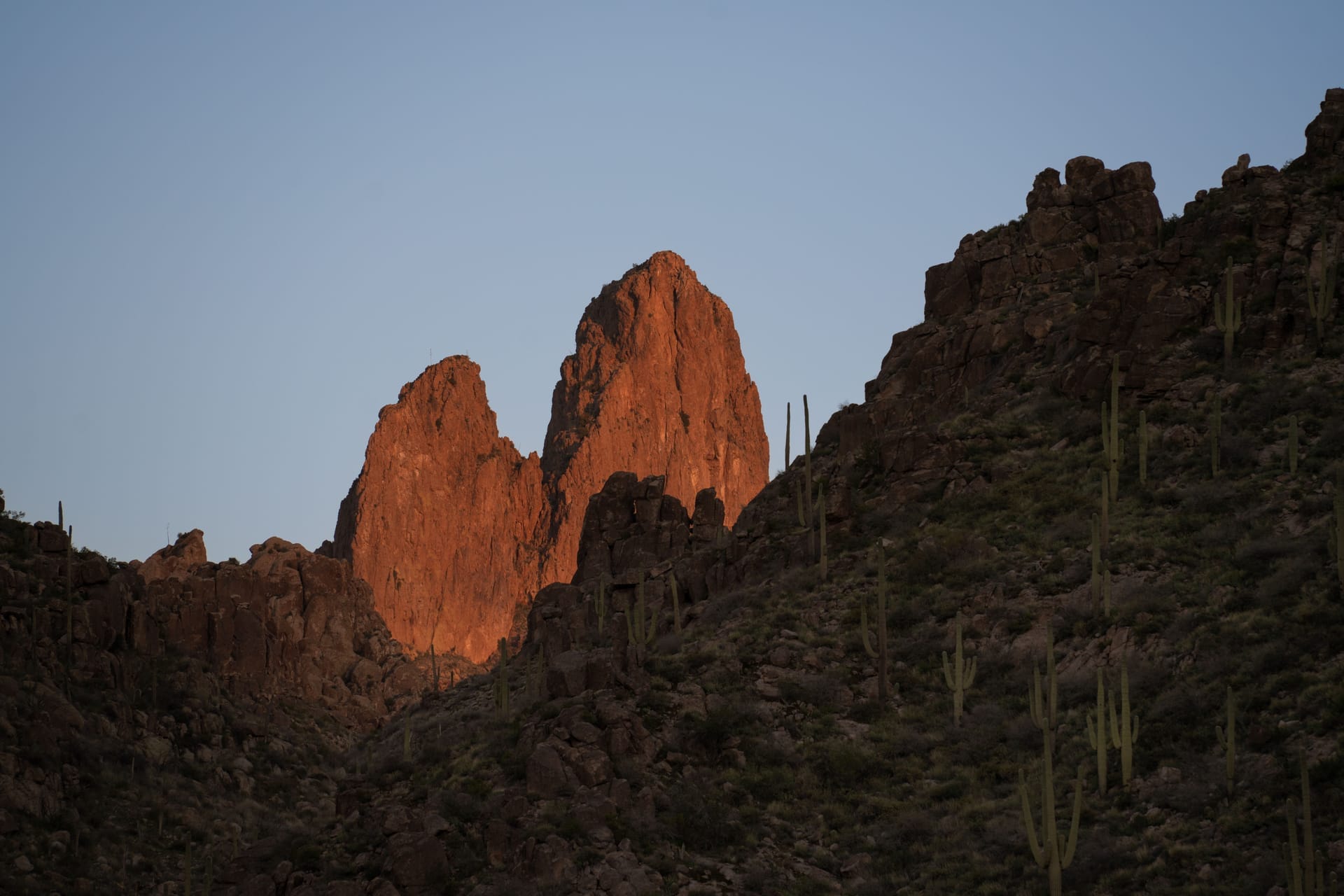 Dramatic sunset lighting on Superstition Mountains in Arizona, featuring rugged rock formations and desert cacti — North Scottsdale, ZIP 85255