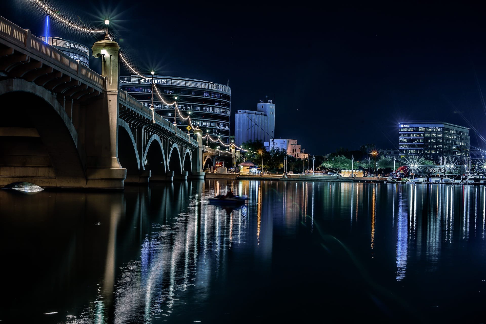 Stunning night view of Tempe, Arizona, featuring the illuminated bridge and skyline reflections on the water