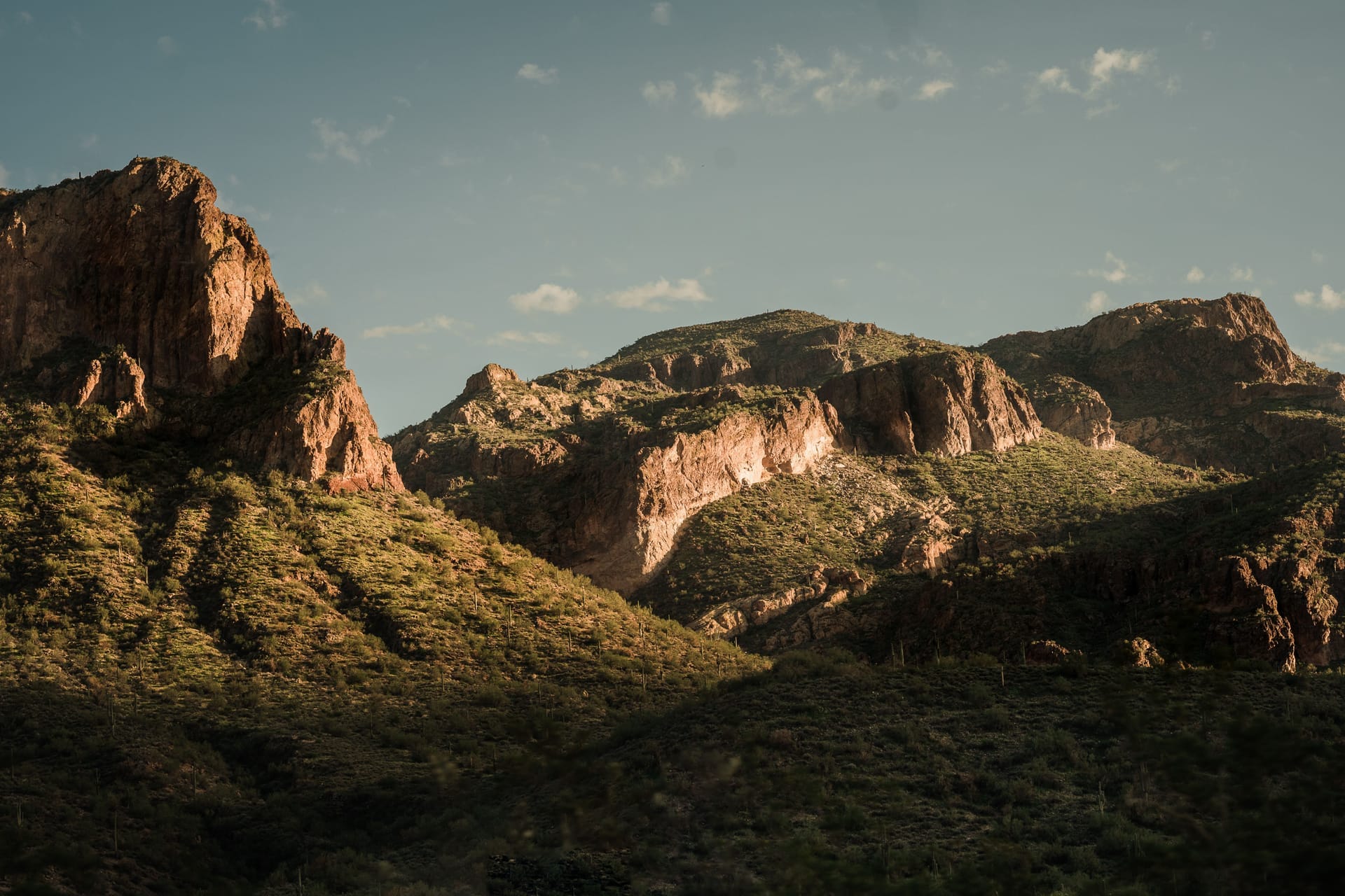 Golden hour light casts shadows on the rugged mountains of Superior, Arizona